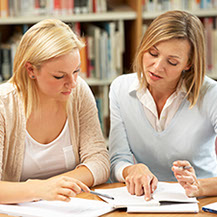 A coach from Your One Degree discusses a workbook exercise with a participant.
